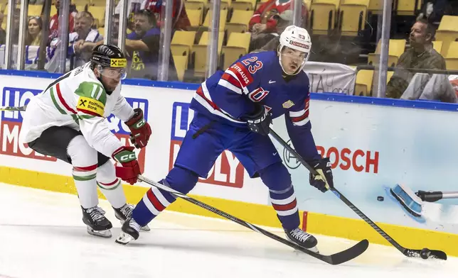 Hungary's defender Gabor Tornyai, left, vies for the puck with USA's forward Mikey Eyssimont, during the IIHF 2025 World Championship preliminary round group B game between USA and Hungary, at the Jyske Bank Boxen, in Herning, Denmark, Sunday, May 11, 2025. (Salvatore Di Nolfi/Keystone via AP)