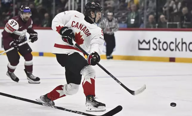 Canada's Kent Johnson scores his side's fourth goal during the IIHF Ice Hockey World Championship group A match between Latvia and Canada at Avicii Arena in Stockholm, Sweden, Sunday, May 11, 2025. (Christine Olsson/TT News Agency via AP)