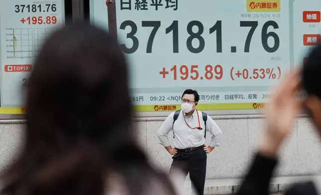 A person stands in front of an electronic stock board showing Japan's Nikkei index at a securities firm Friday, May 23, 2025, in Tokyo. (AP Photo/Eugene Hoshiko)