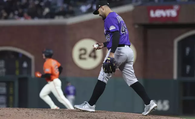 Colorado Rockies pitcher Antonio Senzatela, front, walks back to the mound as San Francisco Giants' Matt Chapman, back, rounds the bases after hitting a home run during the third inning of a baseball game in San Francisco, Friday, May 2, 2025. (AP Photo/Jed Jacobsohn)