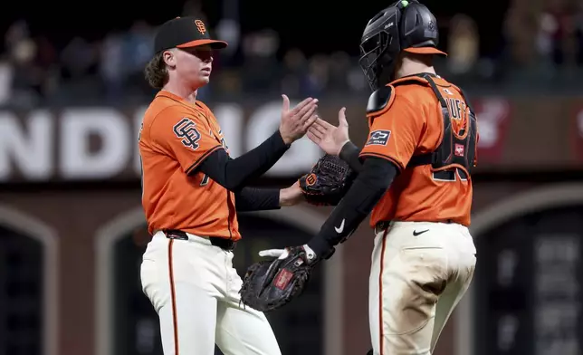 San Francisco Giants pitcher Hayden Birdsong (60) celebrates with catcher Sam Huff (23) after defeating the Colorado Rockies during a baseball game in San Francisco, Friday, May 2, 2025. (AP Photo/Jed Jacobsohn)