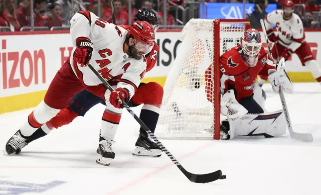 Carolina Hurricanes left wing Jordan Martinook (48) skates with the puck against Washington Capitals goaltender Logan Thompson, right, in the second period of Game 1 of a second-round NHL hockey playoff series Tuesday, May 6, 2025, in Washington. (AP Photo/Nick Wass)