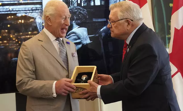 Britain's King Charles, left, is presented with the Key to Canada House by High Commissioner for Canada, Ralph Goodale, during a visit to Canada House to mark 100 years since it opened, at Trafalgar Square, in London, Tuesday May 20, 2025. (Arthur Edwards/Pool via AP)