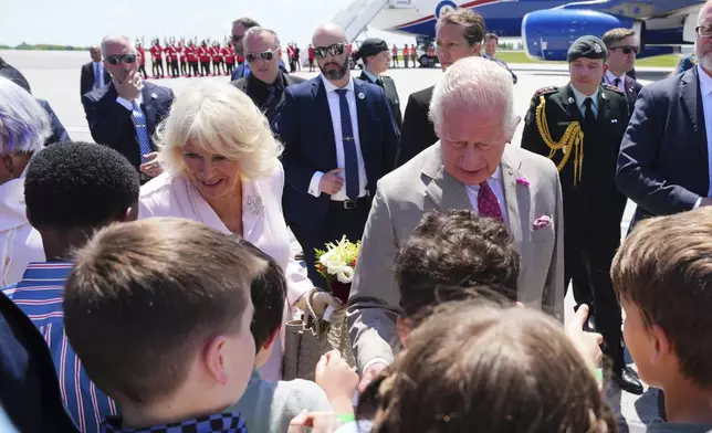 King Charles and Queen Camilla greet school children as they arrive at the Ottawa International Airport in Ottawa, Canada, for a royal visit on Monday, May 26, 2025. (Sean Kilpatrick/The Canadian Press via AP)