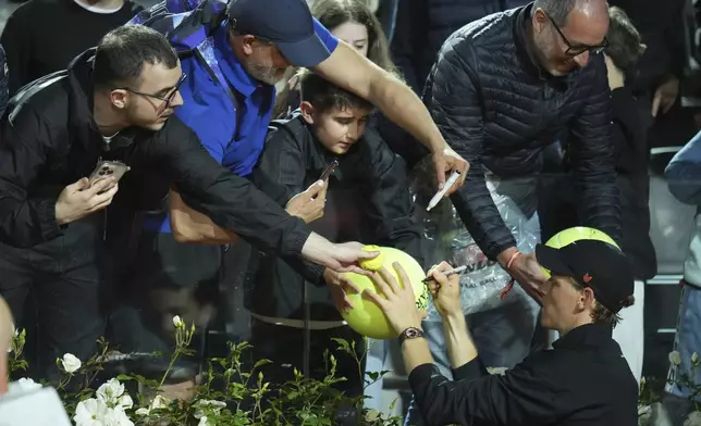 Italy's Jannik Sinner signs autographs after a second round match against Argentina's Mariano Navone at the Italian Open tennis tournament in Rome, Saturday, May 10, 2025. (AP Photo/Andrew Medichini)