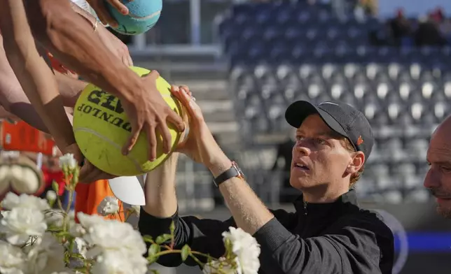 Italy's Jannik Sinner signs autographs after beating Netherlands' Jesper De Jong, at the end of their tennis match at the Italian Open at the Foro Italico, in Rome, Monday, May 12, 2025. (AP Photo/Alessandra Tarantino)