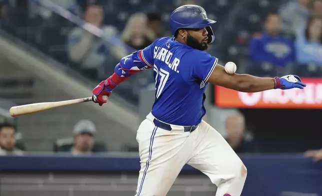 Toronto Blue Jays' Vladimir Guerrero Jr. (27) fouls a ball off his arm against the San Diego Padres during the eighth inning of a baseball game in Toronto on Wednesday, May 21, 2025. (Nathan Denette/The Canadian Press via AP)