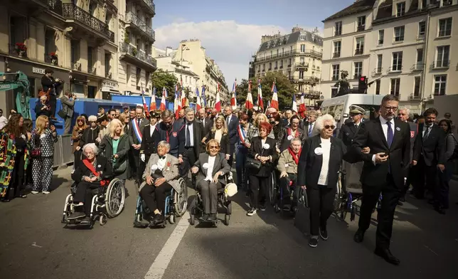 From the left, holocaust survivors Marie-Josee Chombart de Lauwe, Ginette Kolinka, Arlette Testyler, Josette Grabarz, Jacques Altmann, Ester Senot attend a commemoration to mark the 80th anniversary of the return of the deportees, in Paris, France, Sunday, April 27, 2025. (AP Photo/Thomas Padilla)