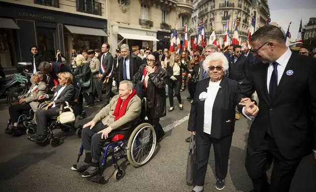 From the left, holocaust survivors Ginette Kolinka, Arlette Testyler, Jacques Altmann, and Ester Senot walk during the commemoration of the 80th anniversary of the return of the deportees, in Paris, France, Sunday, April 27, 2025. (AP Photo/Thomas Padilla)