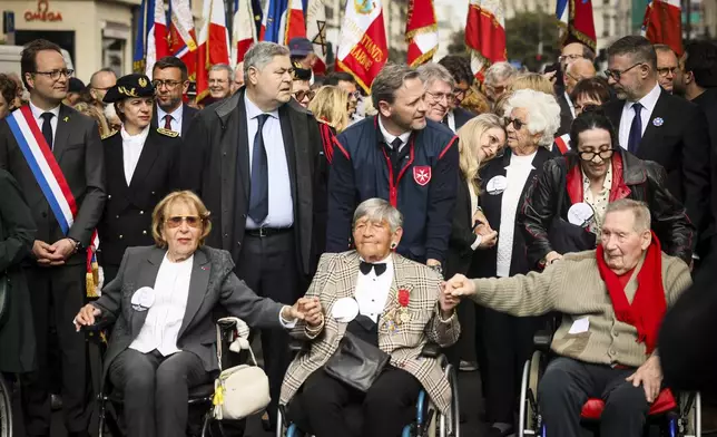 Front from the left, holocaust survivors Arlette Testyler, Ginette Kolinka, Ester Senot, standing with white hair, and Jacques Altmann, attend a ceremony to mark the 80th anniversary of the return of the deportees, in Paris, France, Sunday, April 27, 2025. (AP Photo/Thomas Padilla)