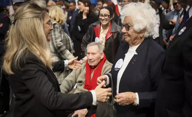 Patricia Miralles, left, French Minister in charge of War Veterans and Memory, welcomes Holocaust survivor Ester Senot at the ceremony marking the 80th anniversary of the return of the deportees, in Paris, France, Sunday, April 27, 2025. (AP Photo/Thomas Padilla)
