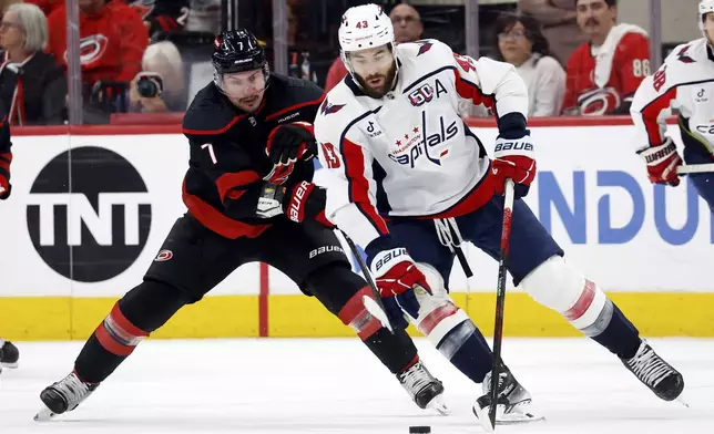 Washington Capitals' Tom Wilson (43) controls the puck in front of Carolina Hurricanes' Dmitry Orlov (7) during the second Game 4 of a second-round NHL hockey playoff series in Raleigh, N.C., Monday, May 12, 2025. (AP Photo/Karl DeBlaker)