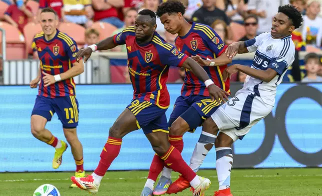 Real Salt Lake striker William Agada (9), Real Salt Lake forward Zavier Gozo, second from right, and Vancouver Whitecaps midfielder Ralph Priso, right, battle for the ball during an MLS soccer match Saturday, May 24, 2025, in Sandy, Utah. (AP Photo/Tyler Tate)
