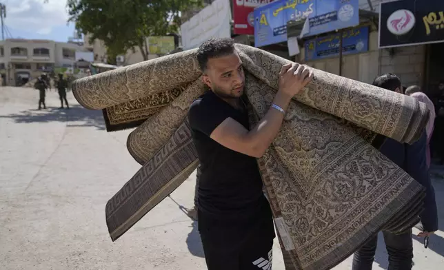 Residents of the now evacuated refugee camp of Tulkarem return to collect belongings before the destruction of their homes as Israeli forces prepared to carry out the demolition of 116 homes across the two refugee camps of the Israeli occupied West Bank city of Tulkarem, Thursday, May 29, 2025. (AP Photo/Nasser Nasser)