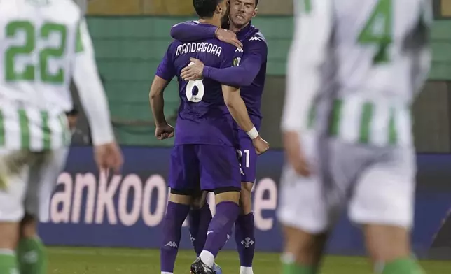 Fiorentina's Robin Gosens, right, celebrates with Rolando Mandragora after scoring a goal during the UEFA Conference League second leg semifinal soccer match between Fiorentina and Real Betis at Artemio Franchi stadium in Florence, Italy, Thursday, May 8, 2025. (Marco Bucco/LaPresse via AP)