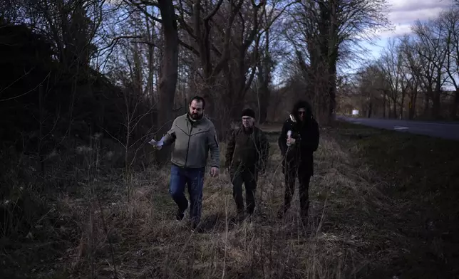 Artur Berger, Tomasz Czabanski and Diane Tempel-Bornett of the German War Graves Commission inspect an area at a forest at the eve of the exhumation of German WWII soldiers in Bedgoszcz, near Szczecin, Poland, Monday, March 17, 2025. (AP Photo/Markus Schreiber)