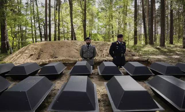 Small coffins with the remains of fallen German soldiers of WWII are placed on the ground during a funeral service at a memorial site for fallen soldiers in Halbe, Germany, Wednesday, April 30, 2025. (AP Photo/Ebrahim Noroozi)