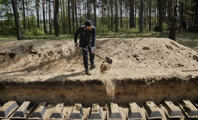 German soldiers bury small coffins with the remains of fallen German soldiers of WWII during a funeral service at a memorial site for fallen soldiers in Halbe, Germany, Wednesday, April 30, 2025. (AP Photo/Ebrahim Noroozi)