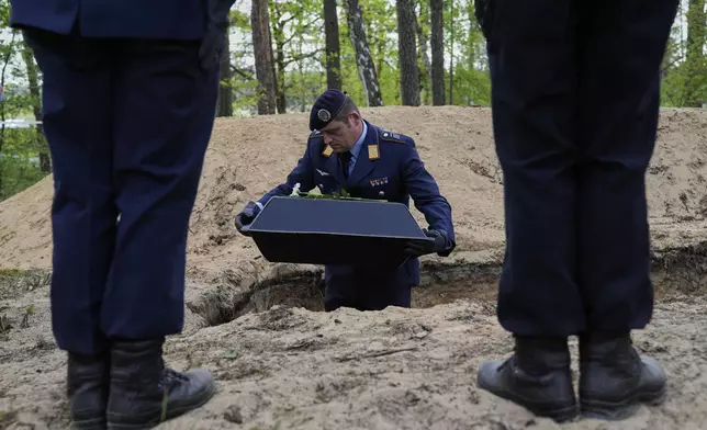 German soldiers carry the small coffins with the remains of fallen German soldiers of WWII to the grave during a funeral service at a memorial site for fallen soldiers in Halbe, Germany, Wednesday, April 30, 2025. (AP Photo/Ebrahim Noroozi)