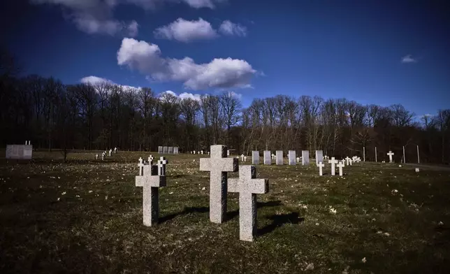 Crosses and grave stones stand on a war cemetery for more than 26.000 fallen German WWII soldiers in Stare Czarnowo, near Szczecin, Poland, Monday, March 17, 2025. (AP Photo/Markus Schreiber)
