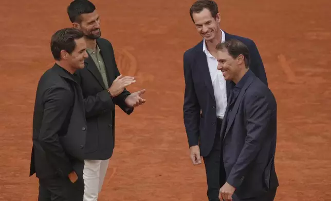 Rafa Nadal, right, is congratulated by Andy Murray, top right, as Roger Federer, left, and Novak Djokovic, during a farewell ceremony at center court Philippe-Chatrier, at the Roland-Garros stadium, in Paris, Sunday May 25, 2025. (AP Photo/Thibault Camus)