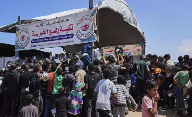 Palestinians struggle to get donated food at a community kitchen in Khan Younis, Gaza Strip, Monday, May 5, 2025. (AP Photo/Abdel Kareem Hana)