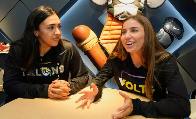Athletes Unlimited Softball League players Charlie Palacios, left, of the Talons, and Sis Bates of the Bolts, are interviewed at Major League Baseball's headquarters in New York, Thursday, May 29, 2025. (AP Photo/Richard Drew)
