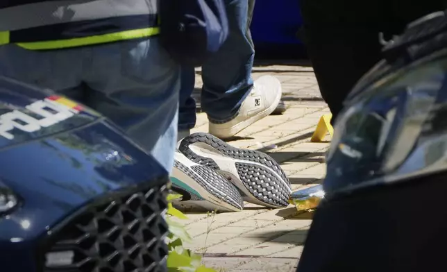 Members of the judicial police work near the body of Andrii Portnov, an adviser to former Ukrainian president Viktor Yanukovych, after Portnov was shot outside a school in Madrid, Spain, Wednesday, May 21, 2025. (AP Photo/Paul White)