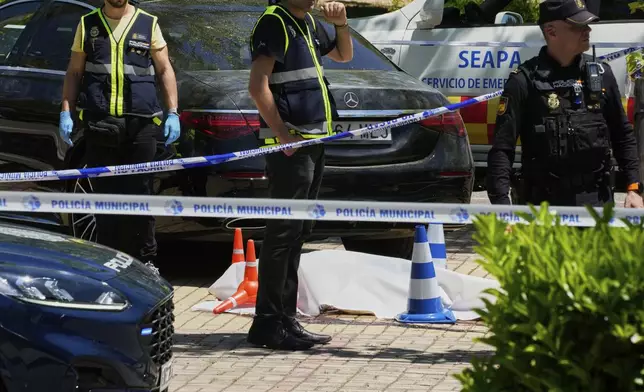 Members of the judicial police at the scene after Andrii Portnov, an adviser to former Ukrainian president Viktor Yanukovych was shot, outside a school in Madrid, Spain, Wednesday, May 21, 2025. (AP Photo/Paul White)