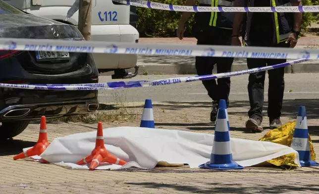 Members of the judicial police at the scene after Andriy Portnov, an adviser to former Ukrainian president Viktor Yanukovych was shot, outside a school in Madrid, Spain, Wednesday, May 21, 2025. (AP Photo/Paul White)