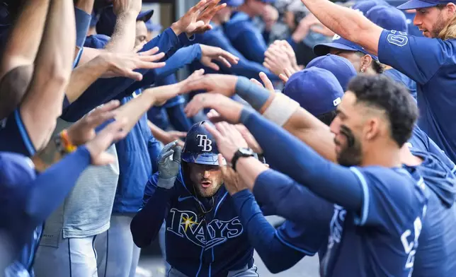 Tampa Bay Rays' Brandon Lowe, center, is greeted in the dugout after hitting a two-run home run in the ninth inning of a baseball game against the Toronto Blue Jays in Toronto, Thursday, May 15, 2025. (Nathan Denette/The Canadian Press via AP)