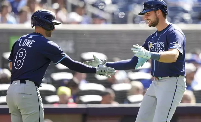 Tampa Bay Rays designated hitter Josh Lowe (15) celebrates his solo home run with teammate Brandon Lowe (8) during the fifth inning of a baseball game against the Tampa Bay Rays in Toronto, Thursday, May 15, 2025. (Nathan Denette/The Canadian Press via AP)