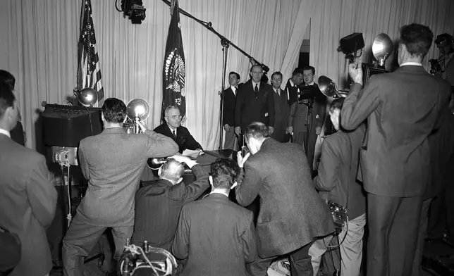 FILE - President Harry S. Truman sits at the close of his radio announcement from the White House in Washington, May 8, 1945 as cameramen record the historic occasion of the announcement of complete victory over the Germans. (AP Photo/Herbert K. White, File)