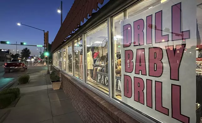 A sign in support of the oil and natural gas industry is displayed in a shop window along a main street in Carlsbad, N.M., on Tuesday, May 20, 2025. (AP Photo/Susan Montoya Bryan)