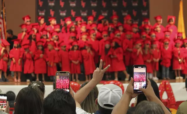 Family and friends take photos of kindergartners at Loving Elementary School graduation ceremony in Loving, N.M., on Tuesday, May 20, 2025. (AP Photo/Susan Montoya Bryan)
