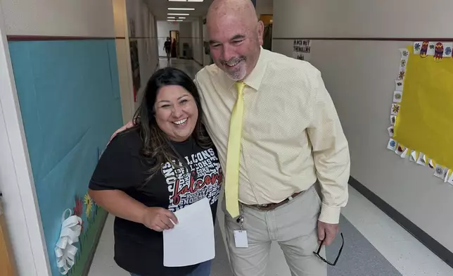 Superintendent Lee White shares a hug with teacher Vanessa Calderon in the hall of the elementary school in Loving, N.M., on Monday, May 19, 2025. (AP Photo/Susan Montoya Bryan)