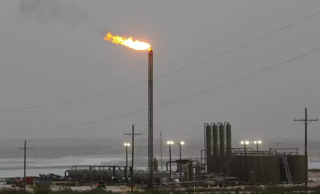 Strong winds kick up dust as a facility in the Permian Basin flares natural gas east of Carlsbad, N.M., on Monday, May 19, 2025. (AP Photo/Susan Montoya Bryan)