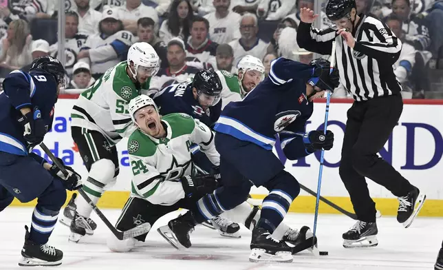Dallas Stars' Roope Hintz (24) reacts after a face-off against Winnipeg Jets' Morgan Barron (right) during first period NHL playoff hockey action in Winnipeg, Thursday, May 15, 2025. (Fred Greenslade/The Canadian Press via AP)