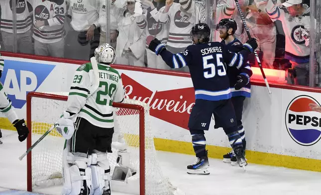 Winnipeg Jets' Mark Scheifele (55) celebrates his goal against Dallas Stars goaltender Jake Oettinger (29) with Kyle Connor (81) during second period NHL playoff hockey action in Winnipeg, Thursday, May 15, 2025. (Fred Greenslade/The Canadian Press via AP)