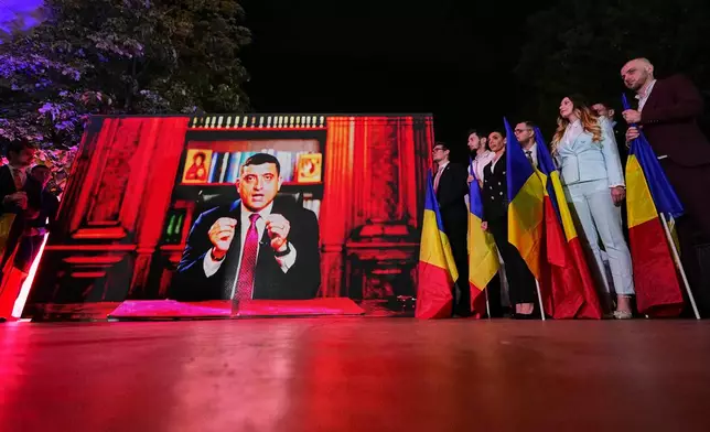 Presidential candidate George Simion addresses supporters via video link after polls closed for the first round of the country's presidential election redo in Bucharest, Romania, Sunday, May 4, 2025. (AP Photo/Andreea Alexandru)