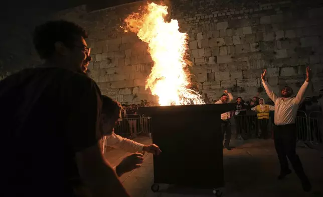 Ultra-Orthodox Jews dance around a bonfire during Lag BaOmer celebrations at the Western Wall, the holiest site where Jews can pray, in the Old City of Jerusalem, Thursday, May 15, 2025. (AP Photo/Ohad Zwigenberg)