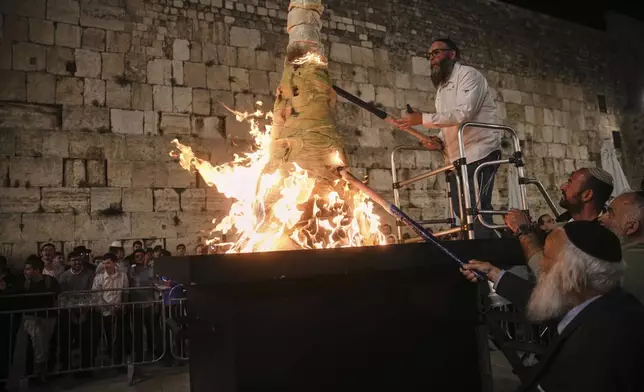 Ultra-Orthodox Jews light a bonfire during Lag BaOmer celebrations at the Western Wall, the holiest site where Jews can pray, in the Old City of Jerusalem, Thursday, May 15, 2025. (AP Photo/Ohad Zwigenberg)