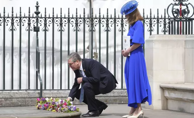 Britain's Prime Minister Keir Starmer and wife Victoria lay down flowers after attending a Service of Thanksgiving at Westminster Abbey on V-E Day in London, Thursday, May 8, 2025.(AP Photo/Kirsty Wigglesworth)