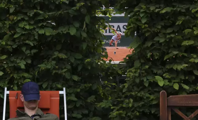 A spectator takes a nap next to a court of the French Tennis Open, at the Roland-Garros stadium, in Paris, Thursday, May 29, 2025. (AP Photo/Lindsey Wasson)