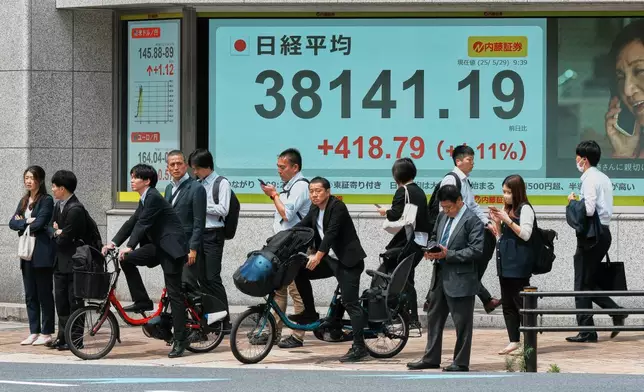 People stand in front of an electronic stock board showing Japan's Nikkei index at a securities firm Thursday, May 29, 2025, in Tokyo. (AP Photo/Eugene Hoshiko)