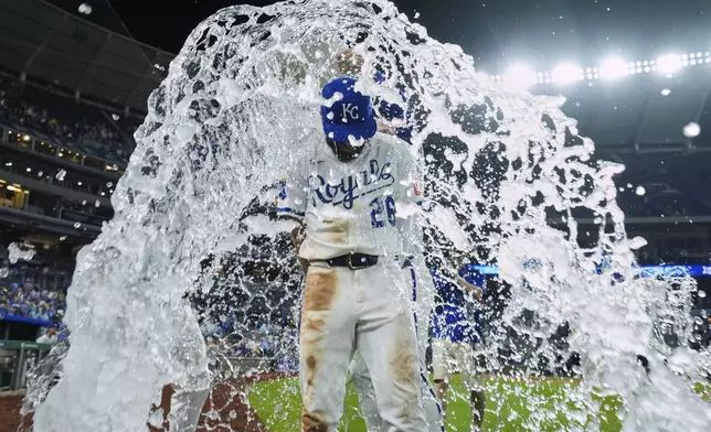 Kansas City Royals' John Rave is doused by teammates after their baseball game against the Cincinnati Reds, Wednesday, May 28, 2025, in Kansas City, Mo. (AP Photo/Charlie Riedel)