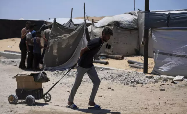 A Palestinian man carries humanitarian aid delivered by the U.S.-backed Gaza Humanitarian Foundation, after receiving the supplies in Rafah, as he arrive in Khan Younis, southern Gaza Strip, on Wednesday, May 28, 2025. (AP Photo/Abdel Kareem Hana)