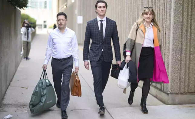 Alex Formenton, center, one of five members of Canada’s 2018 world junior hockey team charged with sexual assault last year for an incident that allegedly took place in June 2018, leaves the London Courthouse in London, Ontario, Friday, May 2, 2025. (Geoff Robins/The Canadian Press via AP)
