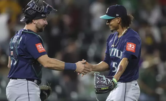 Seattle Mariners catcher Cal Raleigh, left, and pitcher Carlos Vargas celebrate their victory over the Athletics during the ninth inning of a baseball game Tuesday, May 6, 2025, in West Sacramento, Calif. (AP Photo/Scott Marshall)