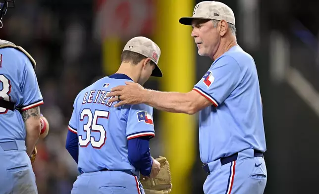 Texas Rangers manager Bruce Bochy, right, takes the ball from starting pitcher Jack Leiter (35) during the eighth inning of a baseball game against the Houston Astros in Arlington, Texas, Sunday, May 18, 2025. (AP Photo/Jerome Miron)